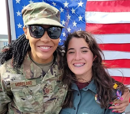 Karis Hunt with a U.S. Air Force member in front of the flag